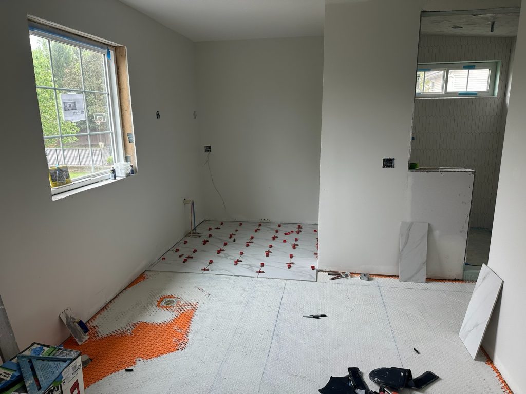 Floor tile being set with leveling clips over the membrane