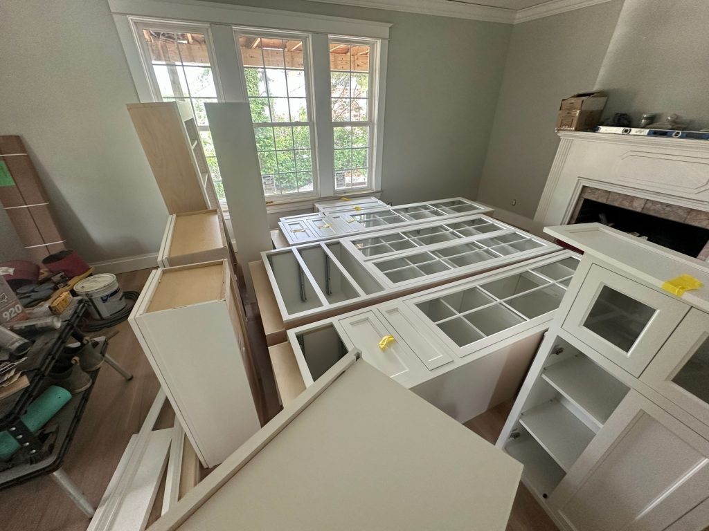 Kitchen cabinetry and glass-front doors staged before installation