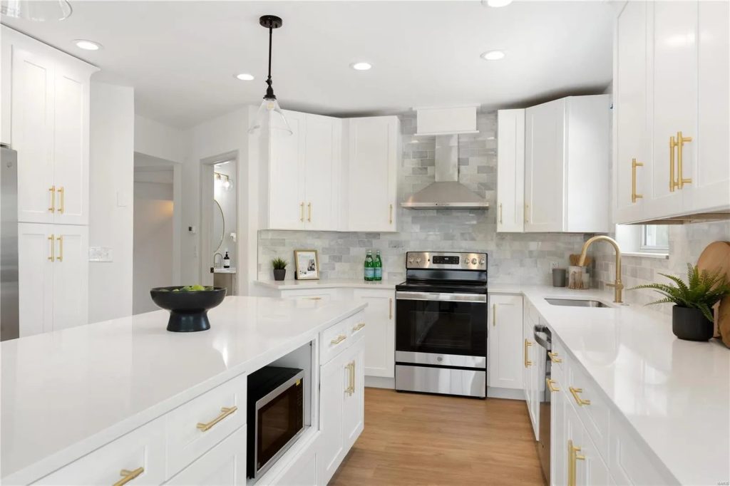 Kitchen with white cabinets, gold hardware and quartz countertops