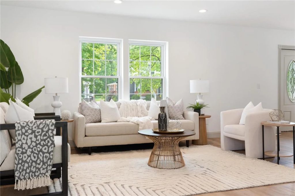 Living room with cream sofas and two windows
