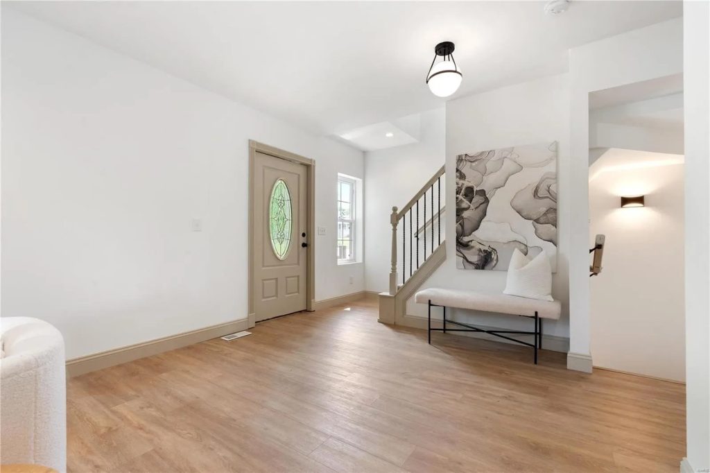 Entry hall with oval glass front door and staircase