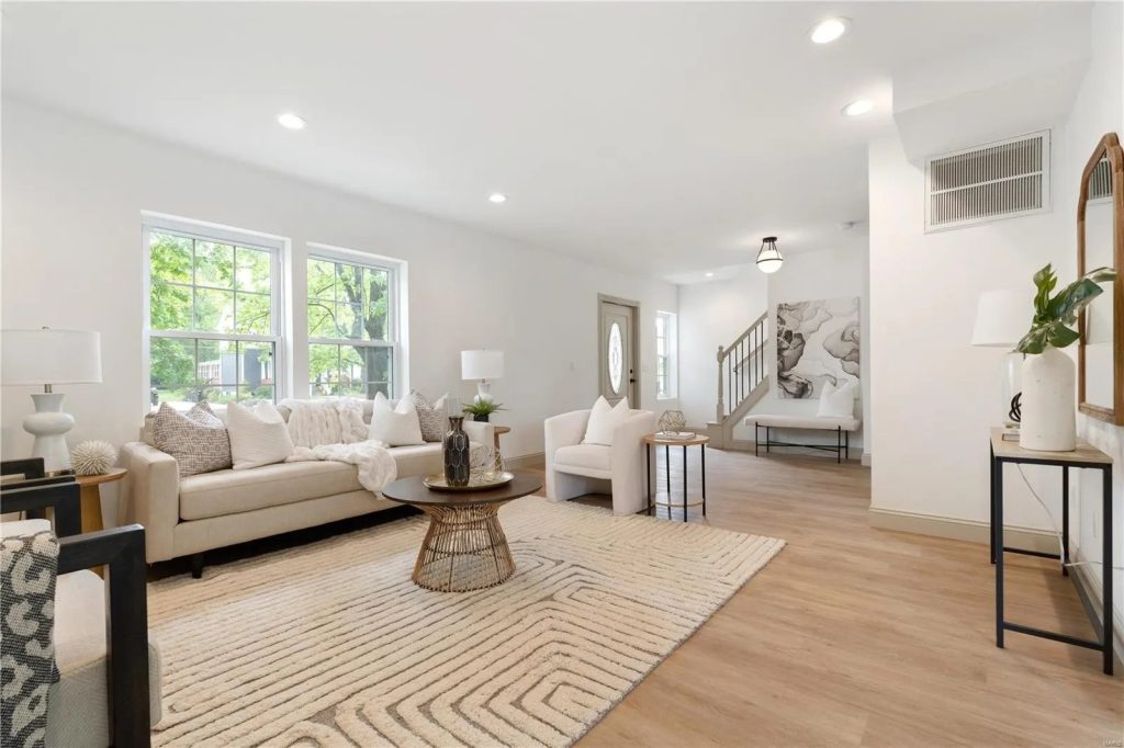 Living room with sofas, armchairs and staircase beyond