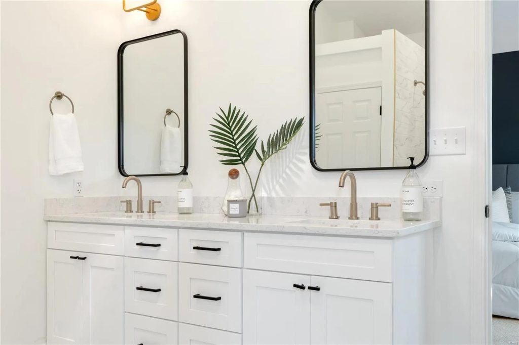 Bathroom with white double vanity and two black framed mirrors