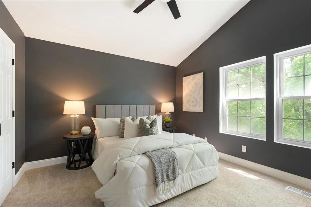 Bedroom with dark accent wall and ceiling fan