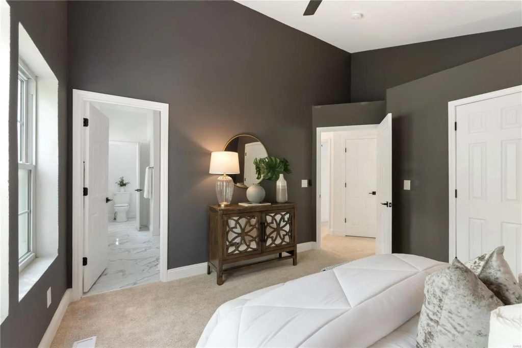 Bedroom with dark accent wall and en suite doorway