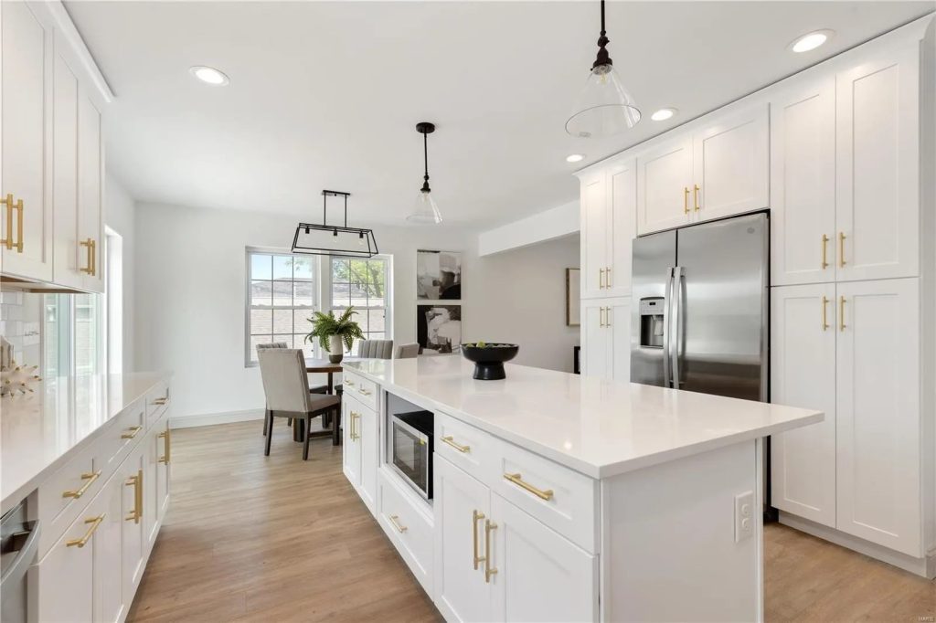 Kitchen with white cabinetry, island and dining area