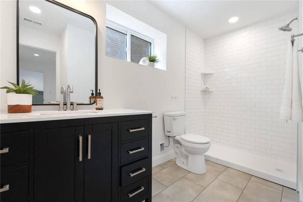 Bathroom with navy vanity and tiled shower