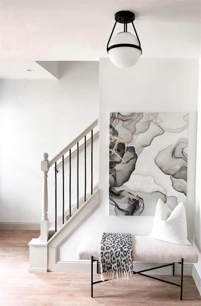 Staircase with bench and framed artwork