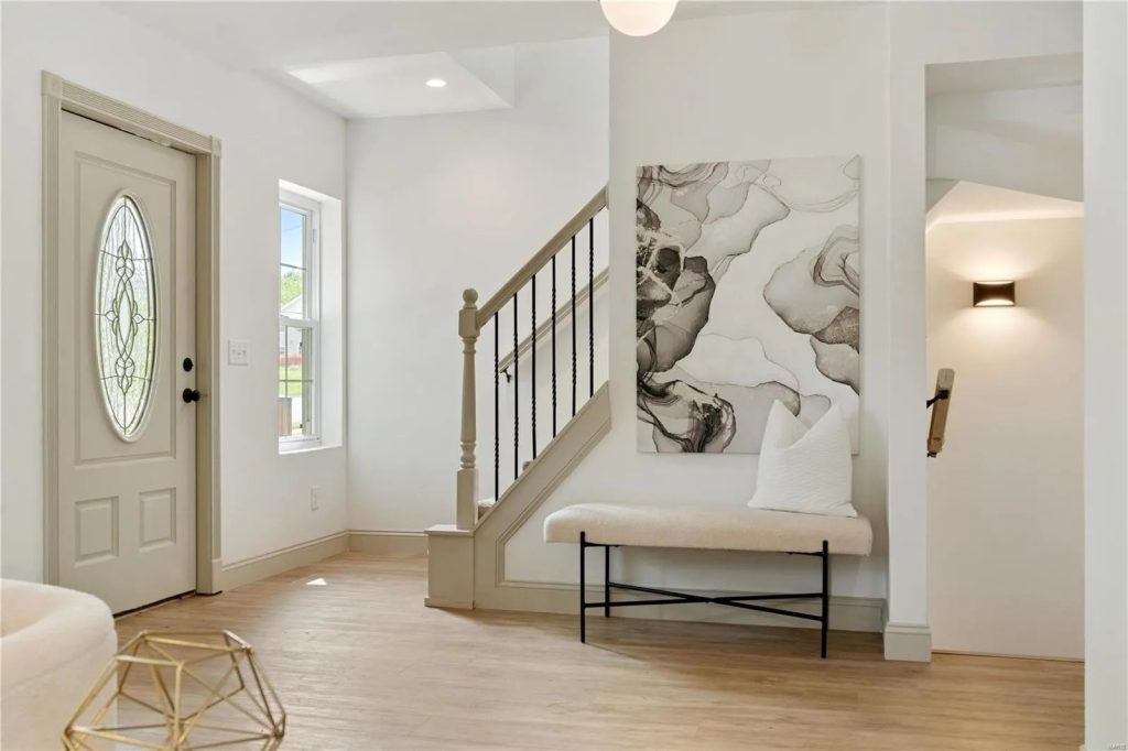 Entry hall with oval glass door and staircase