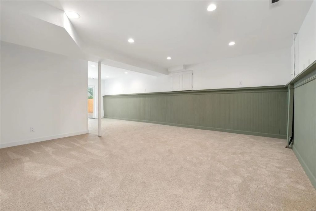 Finished lower level with green wainscot and carpet