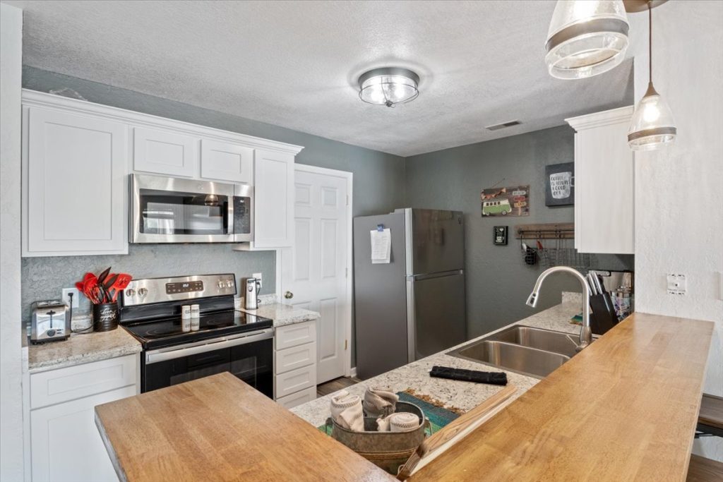 Kitchen with stainless appliances and butcher block bar