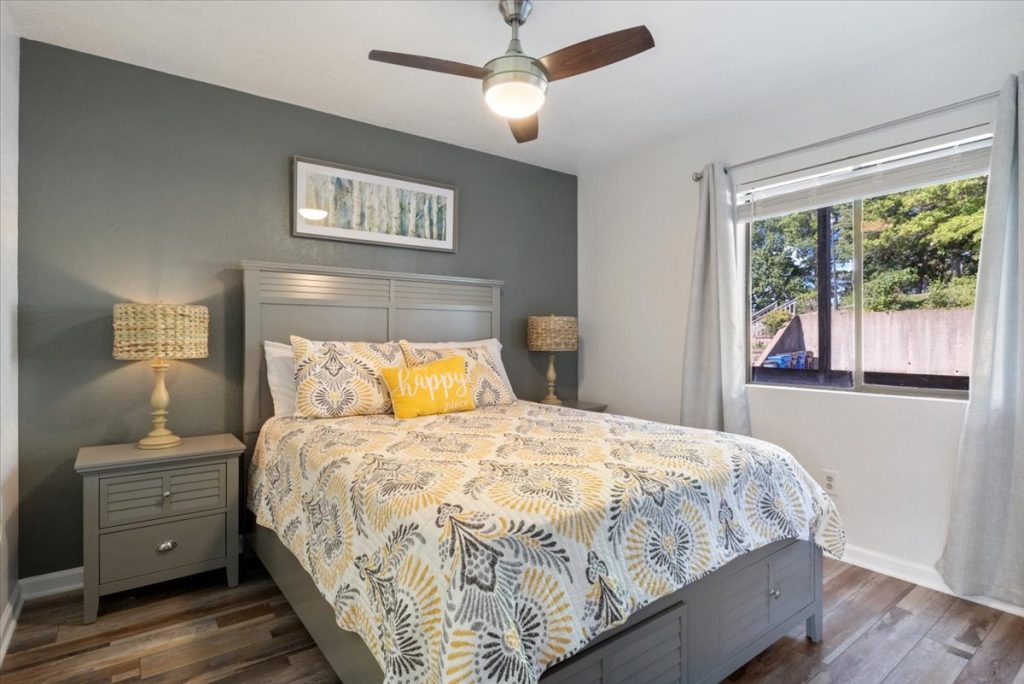 Bedroom with gray headboard and yellow patterned bedding