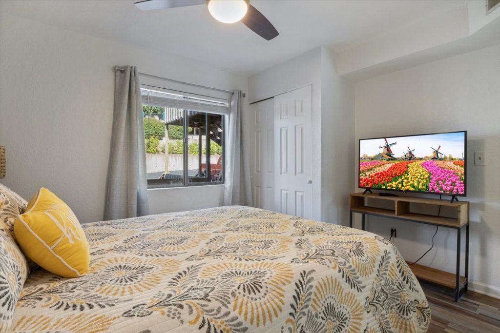 Bedroom with yellow patterned bedding and television