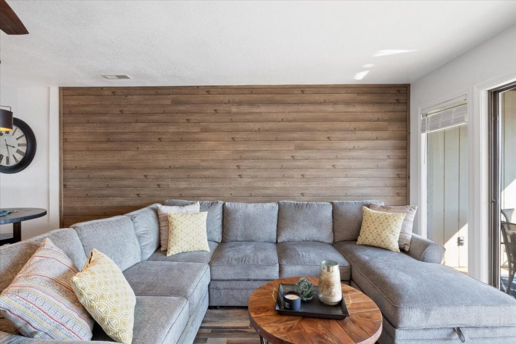Living room with gray sectional and wood accent wall