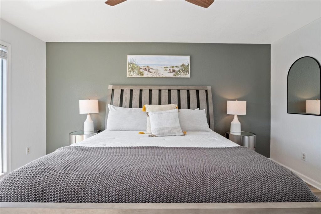 Bedroom with gray bedding and arched mirror