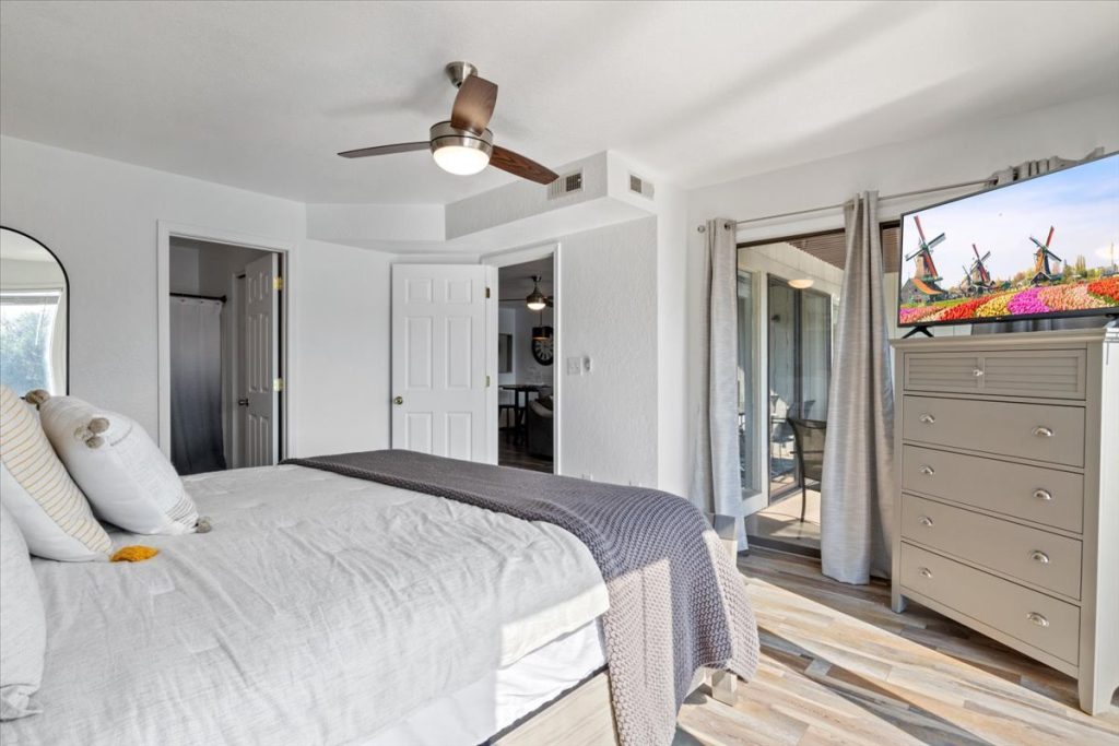 Bedroom with television, dresser and balcony doors