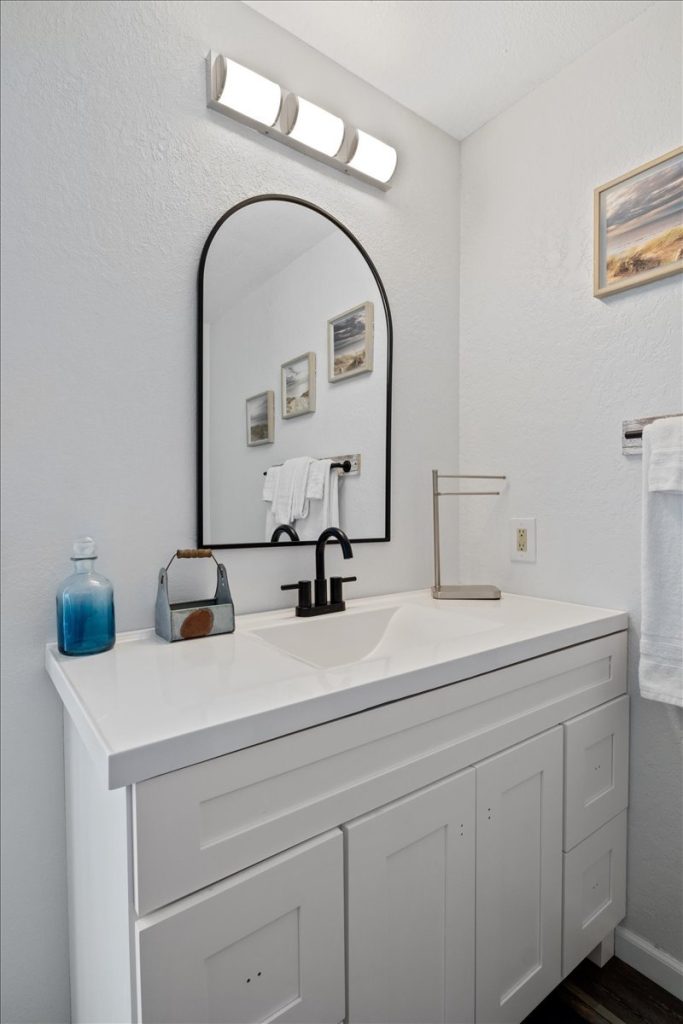 Bathroom with white vanity and arched mirror