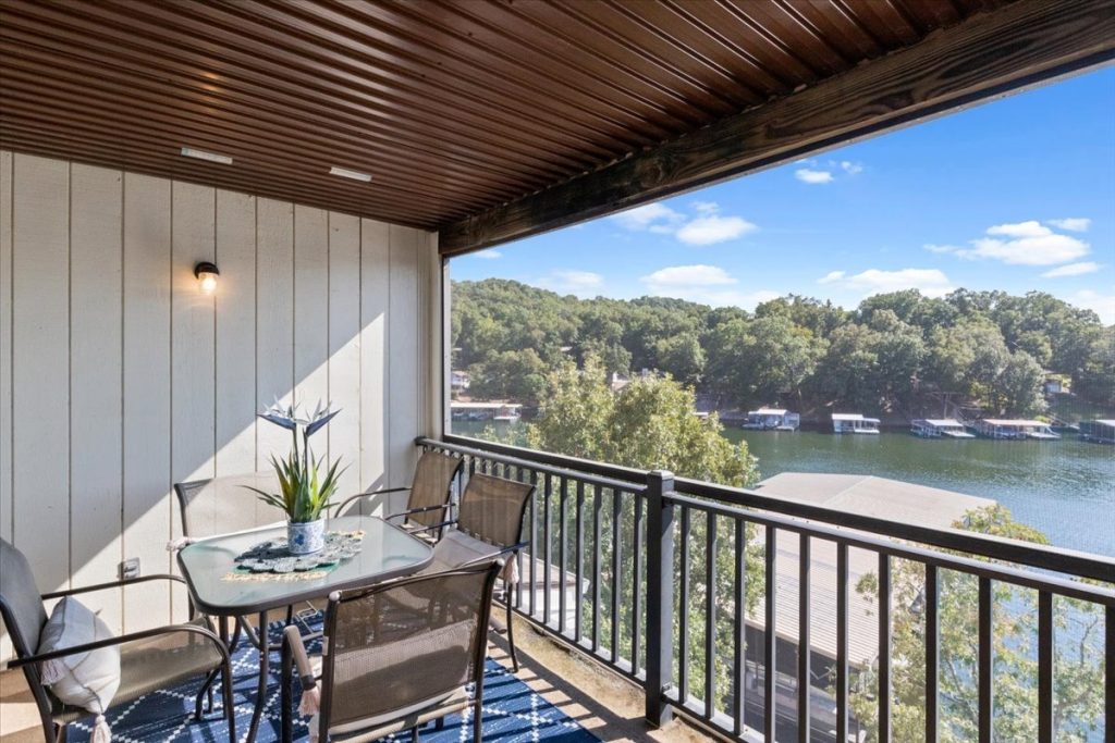 Covered balcony with table, chairs and lake view