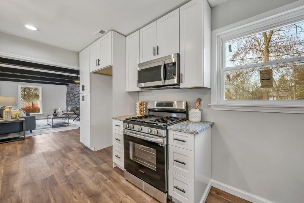 Kitchen with white cabinets, stainless range and granite countertop