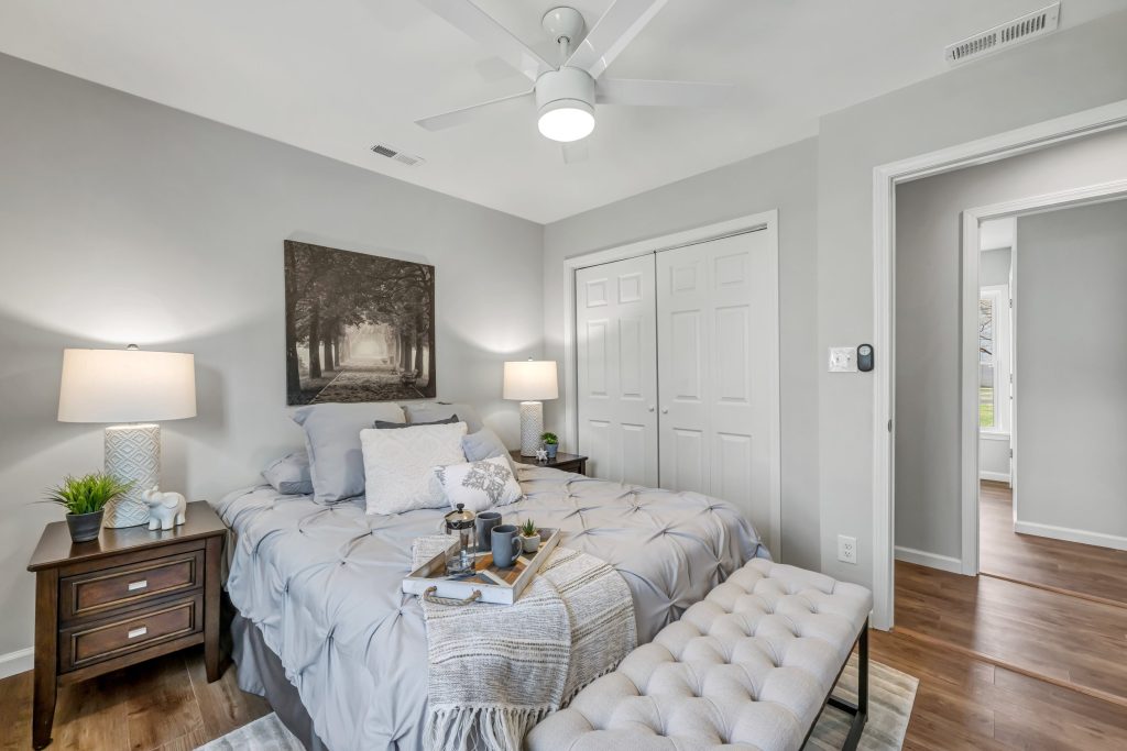 Bedroom with upholstered bench and closet doors