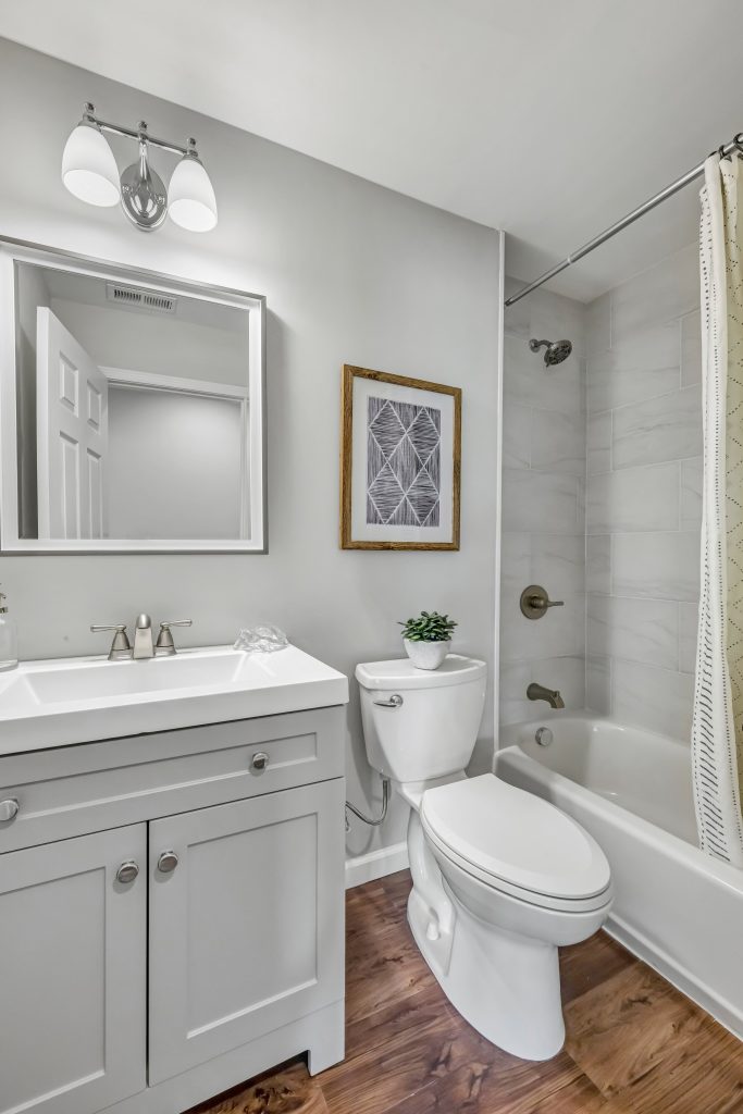 Bathroom with vanity, framed mirror and tiled tub