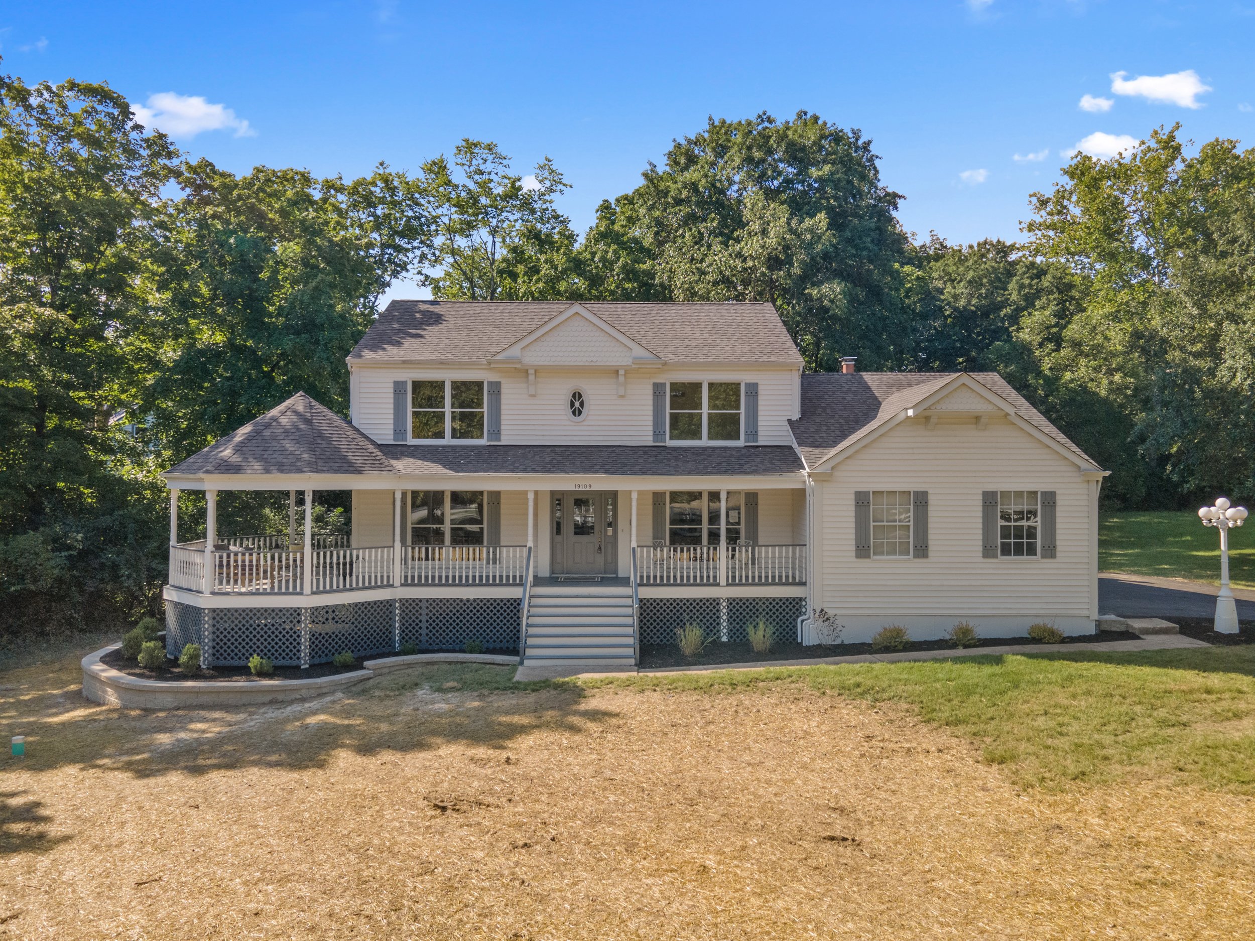 White two story house with wraparound porch