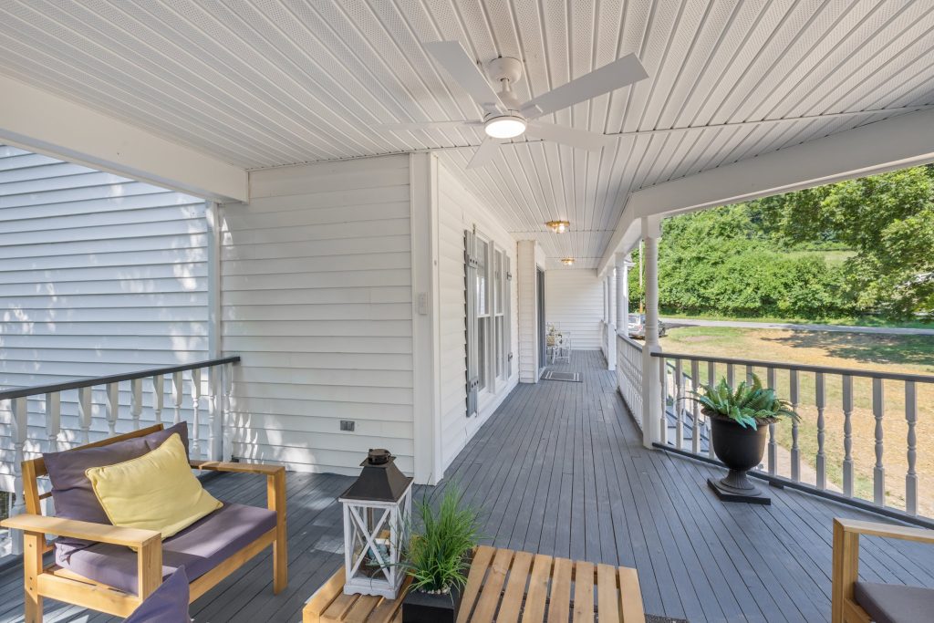 Covered porch with seating and gray decking