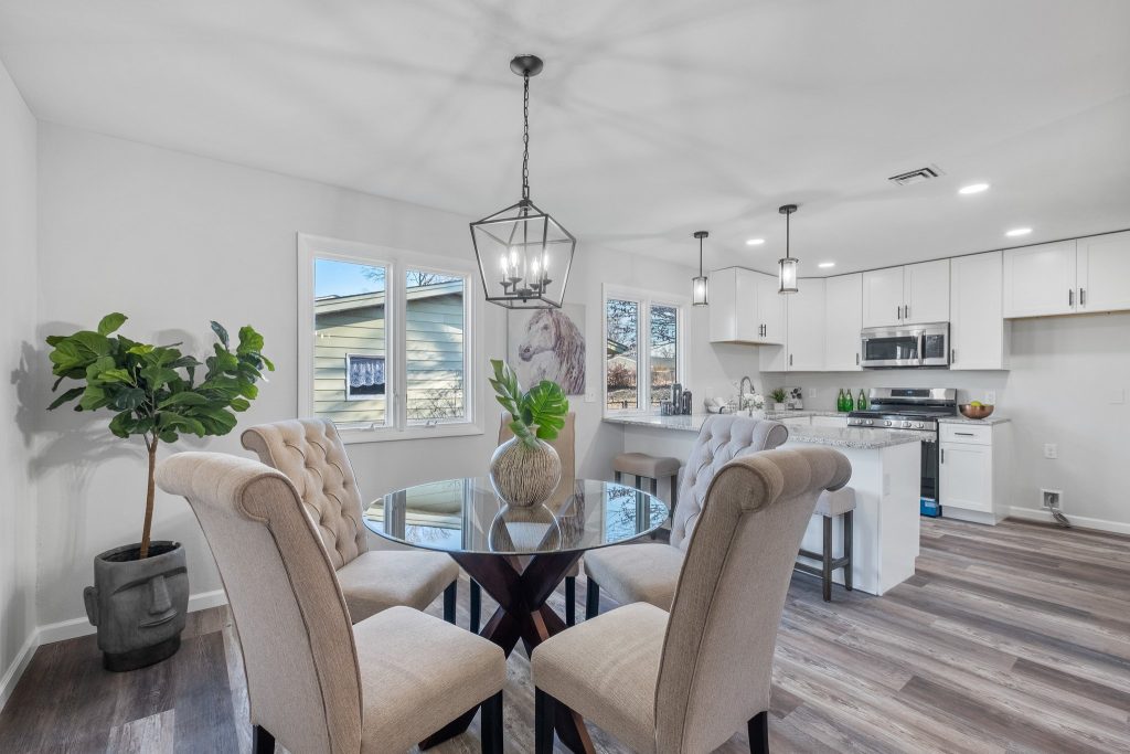 Dining table with upholstered chairs and kitchen beyond