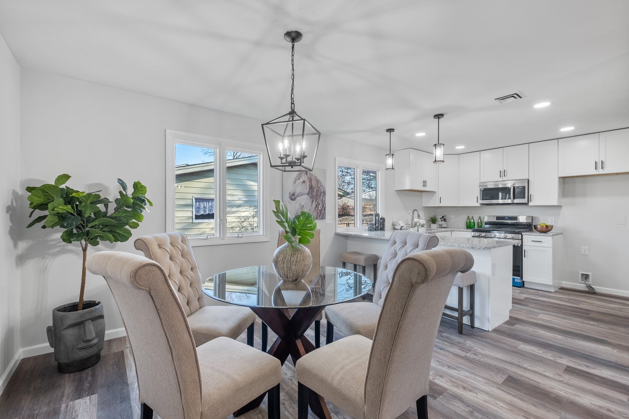 Dining table with upholstered chairs and kitchen beyond