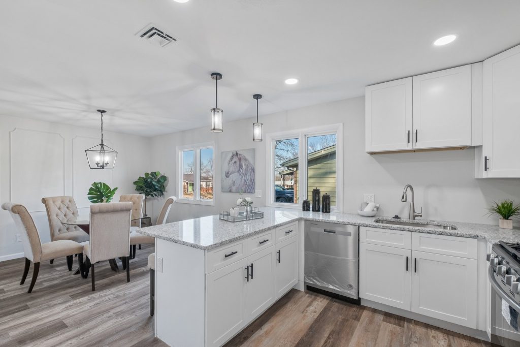 Kitchen with white cabinets, granite island and dining area