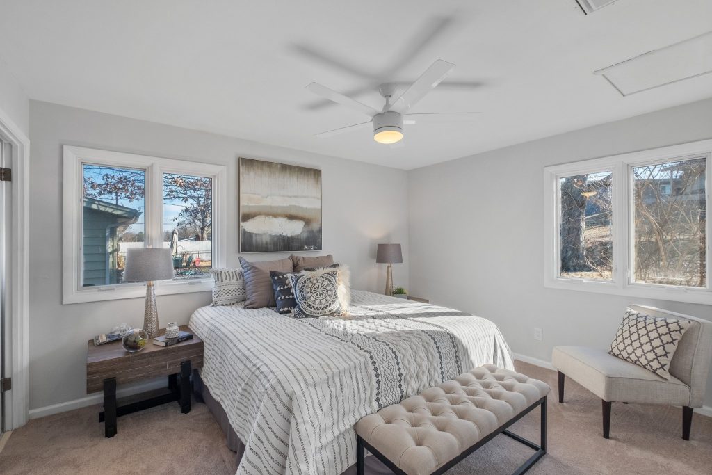 Bedroom with upholstered bench and two windows