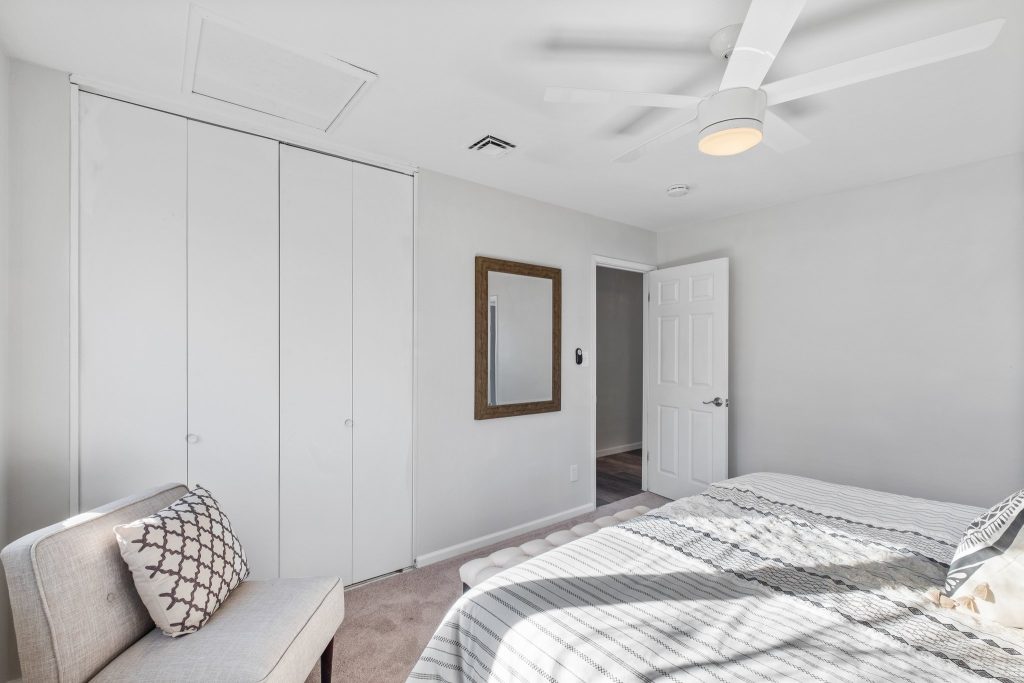 Bedroom with closet doors and armchair