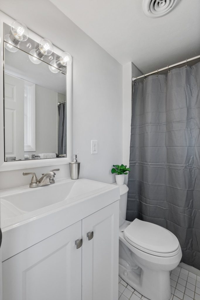 Bathroom with gray vanity, framed mirror and shower curtain